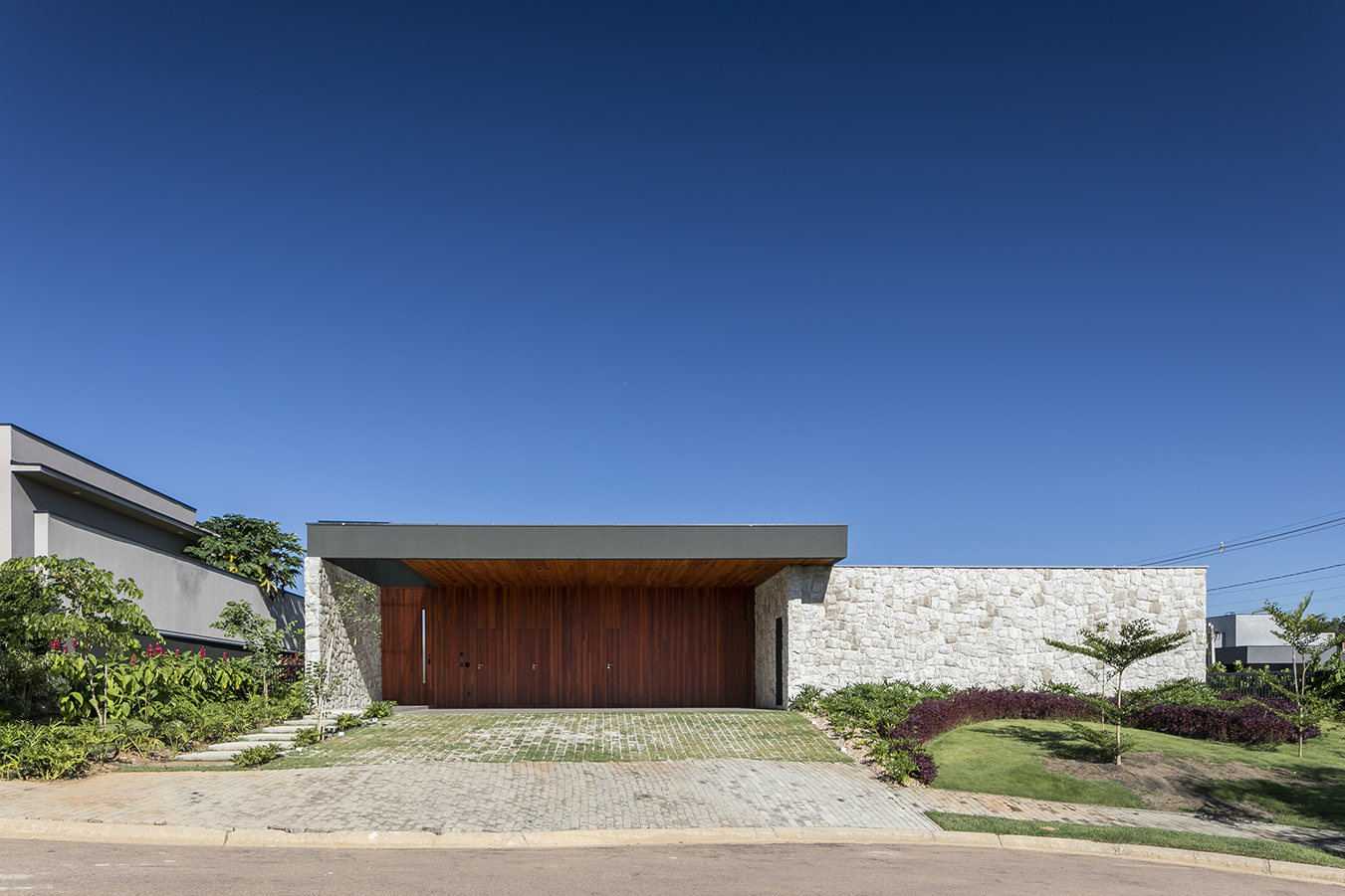 fachada casa térrea com pedra, concreto e madeira arquitetura contemporanea