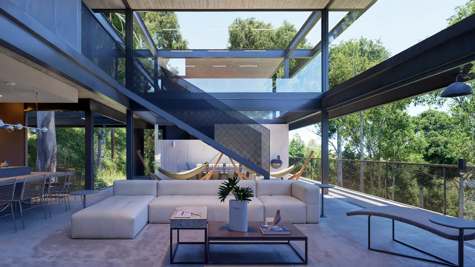 casa-suspensa-piso-metalico-vazado-06 Acesso por passarela elevada conduzindo à casa suspensa entre árvores