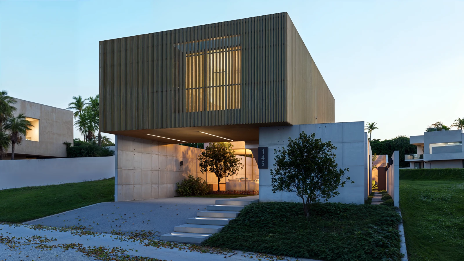 Casa moderna com volume superior em madeira suspenso sobre base em concreto aparente