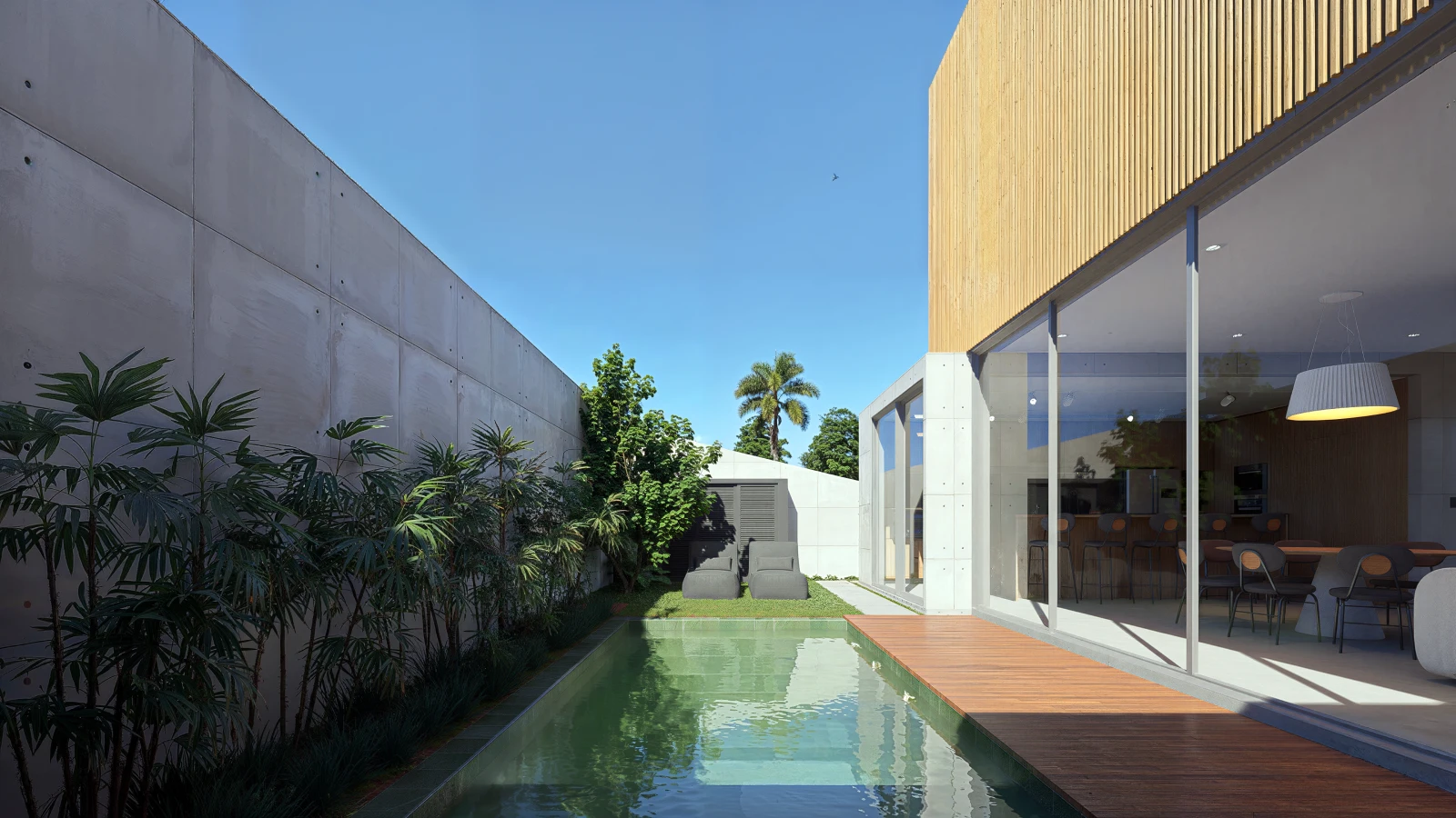 Piscina lateral com deck de madeira integrada à residência e jardim